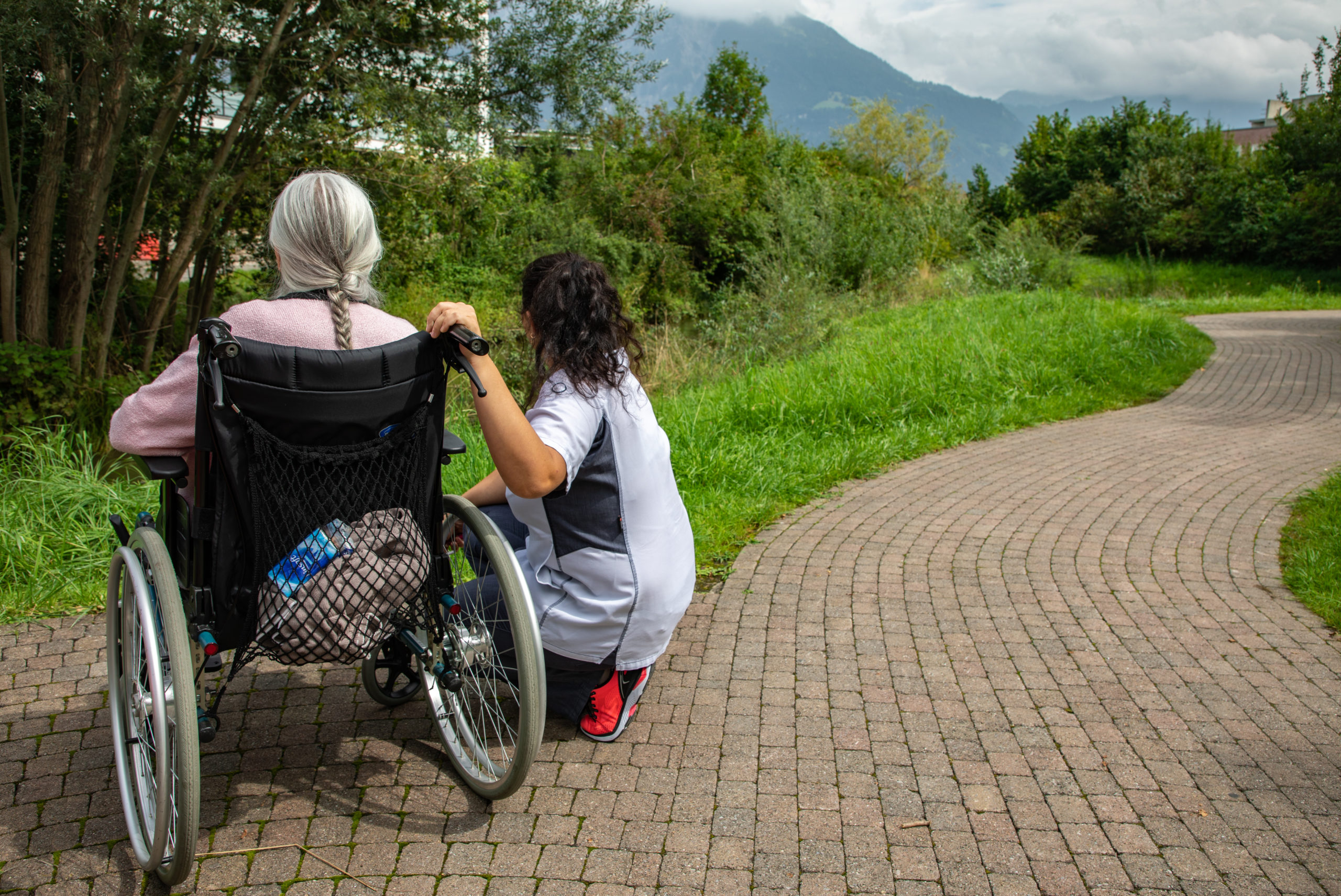 Bild von Frau im Rollstuhl mit Pflegefachperson